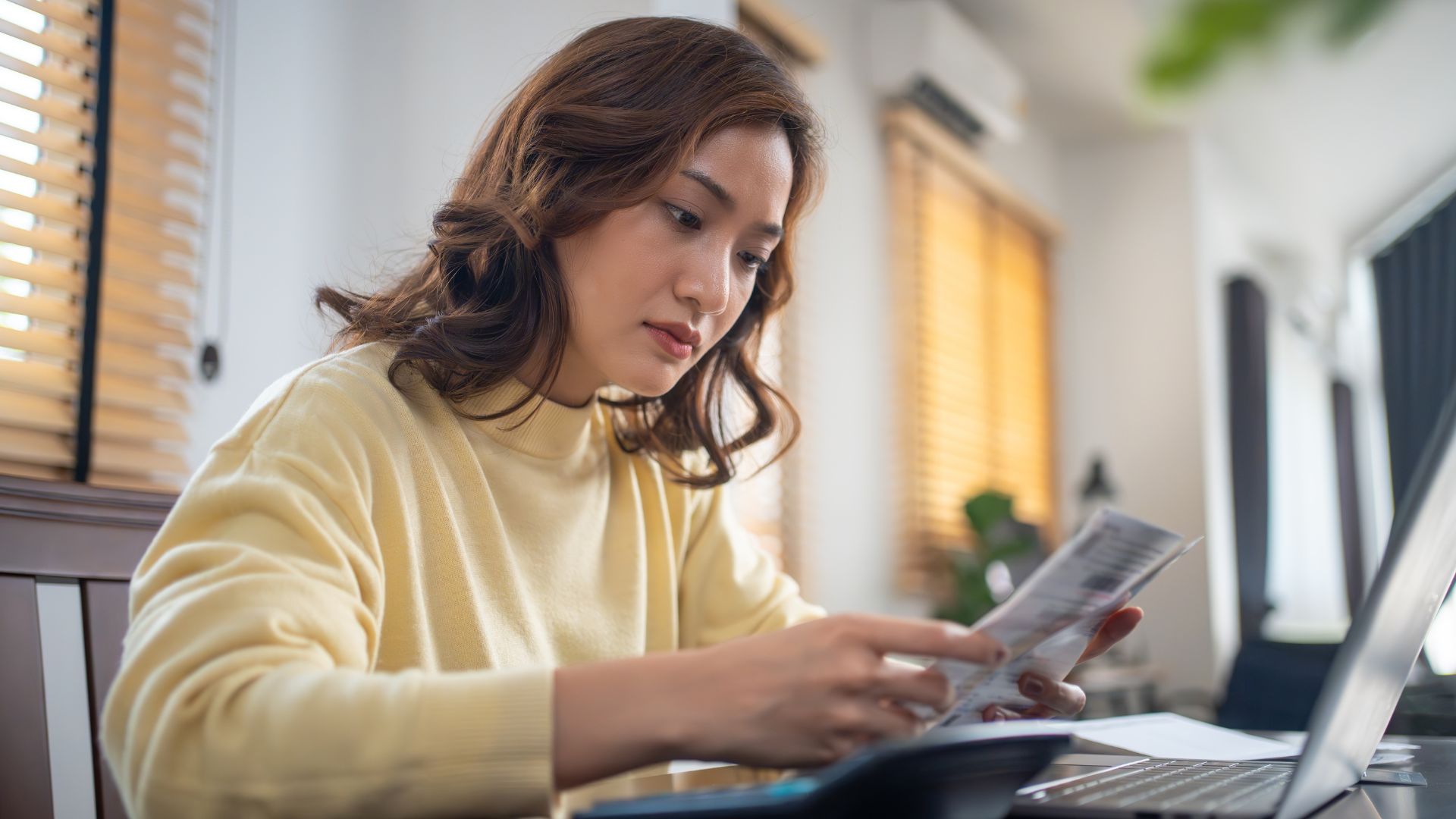 A woman looking at her finances to assess why she has been blacklisted and what steps to take