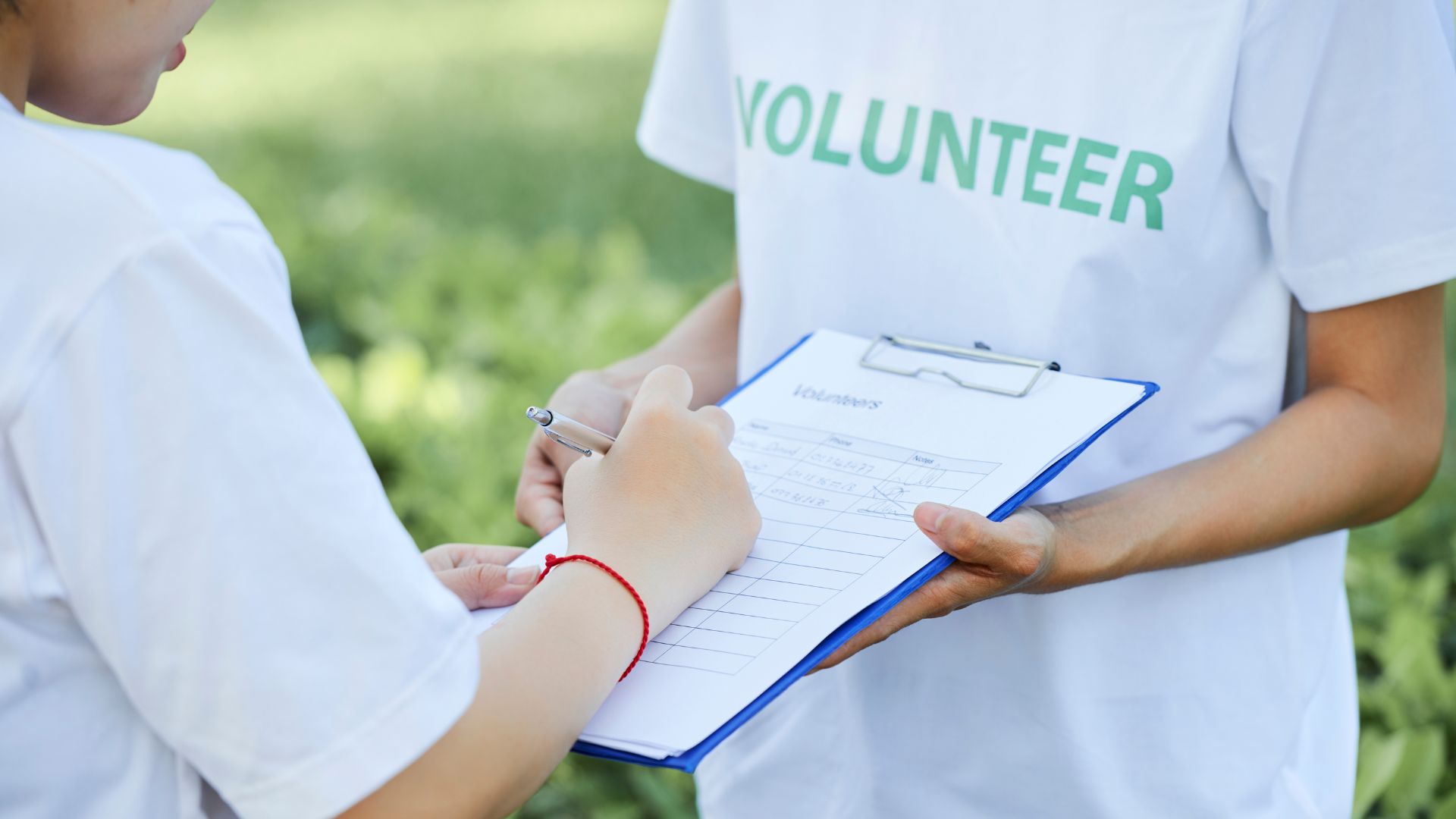 A volunteer for an NPO collecting signatures on a clipboard