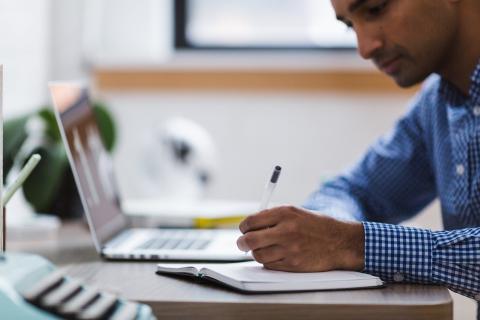 A man writing to represent how to write a CV when applying to a law firm.